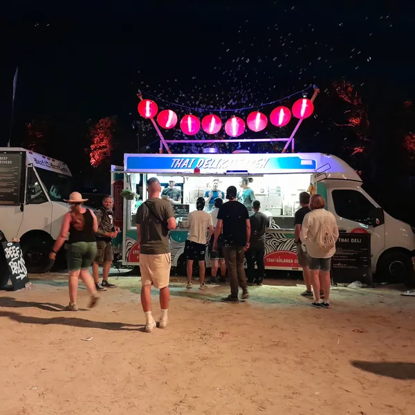 Der beleuchtete Foodtruck nachts auf einem Festival